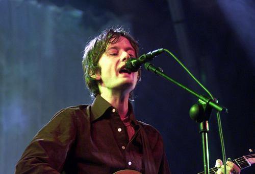 Jarvis Cocker playing guitar on stage at the Eden Project